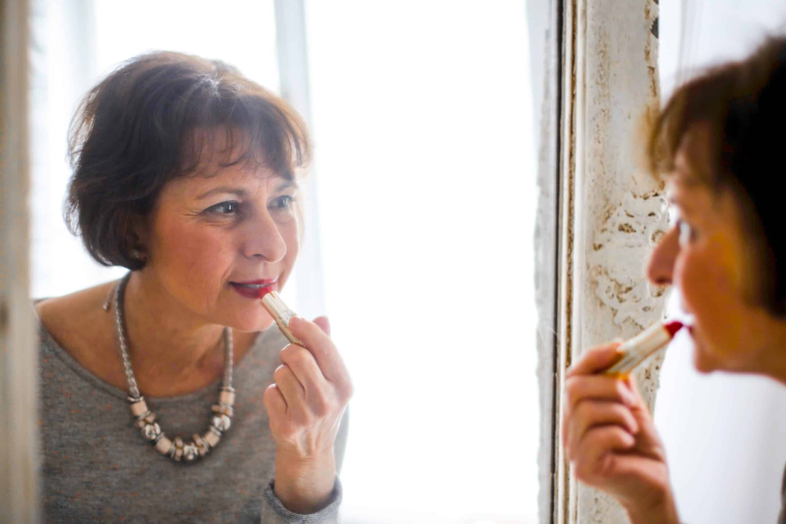 Lady putting on lipstick